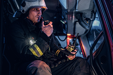 Fireman sitting in the fire truck and talking on the radio